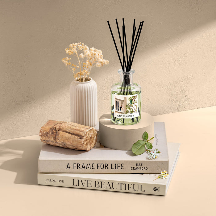 Elle Cadeaux White Jasmine 6oz premium reed diffuser with clear glass bottle and black reeds, styled with white vase, driftwood and books