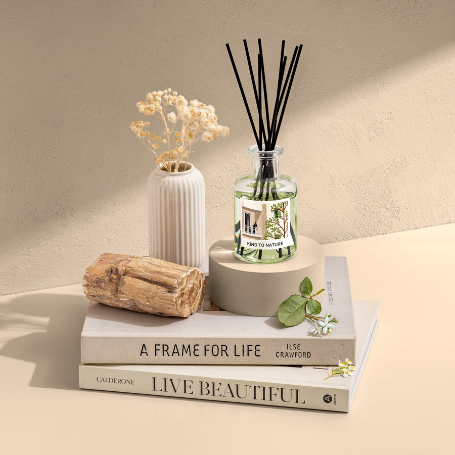 Elle Cadeaux White Jasmine 6oz premium reed diffuser with clear glass bottle and black reeds, styled with white vase, driftwood and books